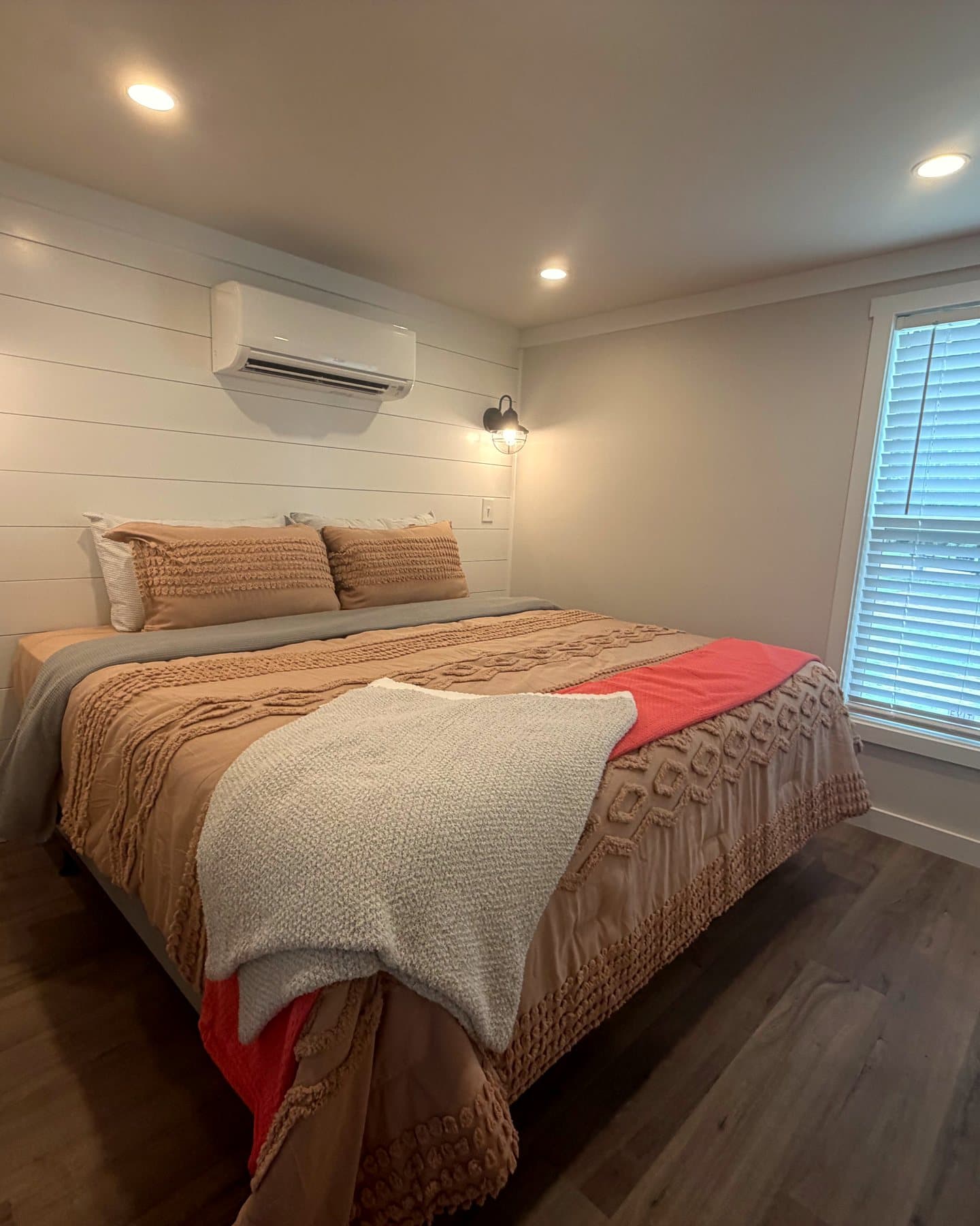 Made-up bed in window light in a Riverbend home