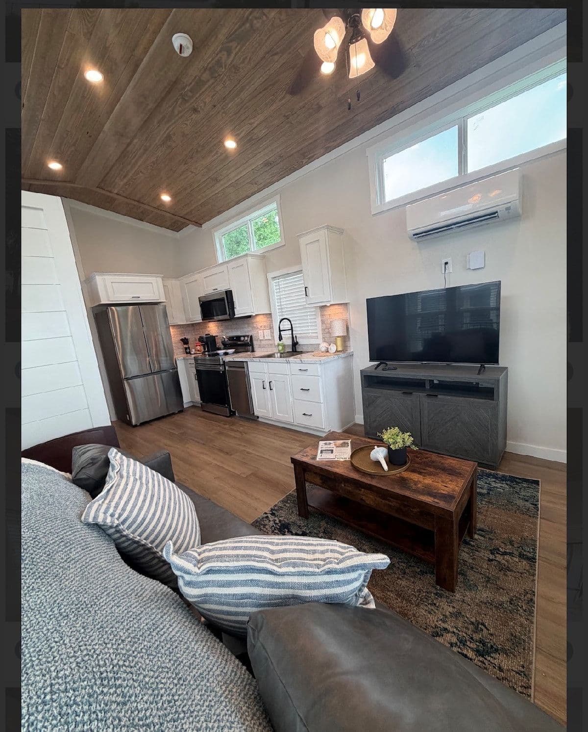 Living area from the sofa toward the kitchen under a wood ceiling