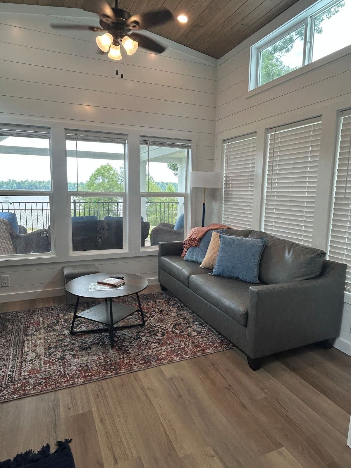 Living room with sofa, round table and windows to the river
