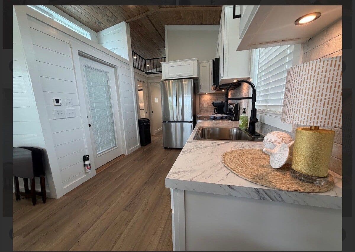 Marble counter, black faucet and fridge in the kitchen