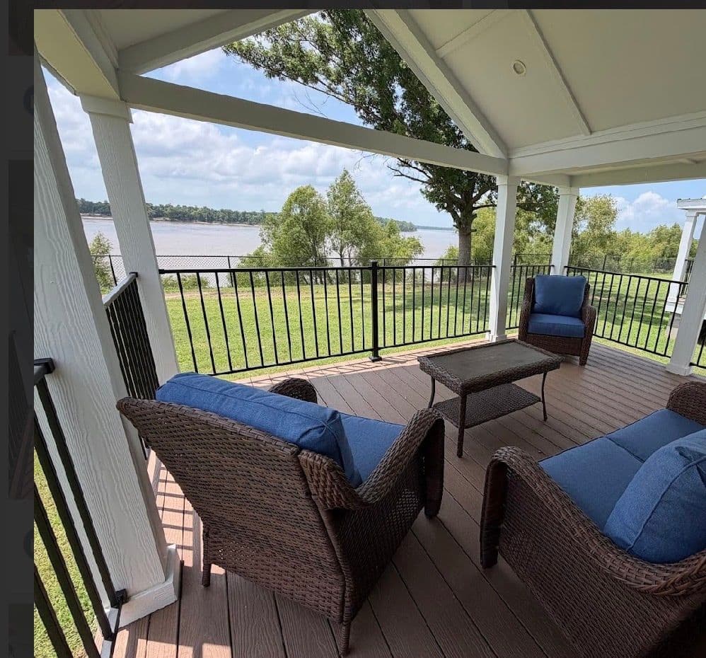 Covered porch with blue chairs and a river view