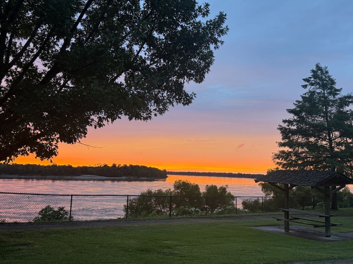 Sunset over the river with the lawn and trees
