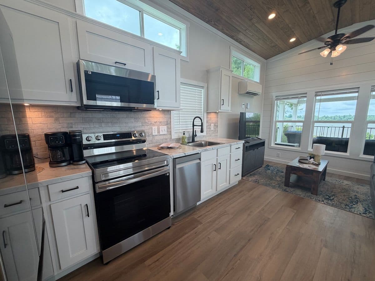Kitchen from the front: stainless range, microwave, ceiling fan and river windows