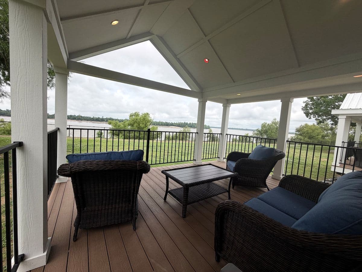 Covered porch with dark cushioned seating and river view
