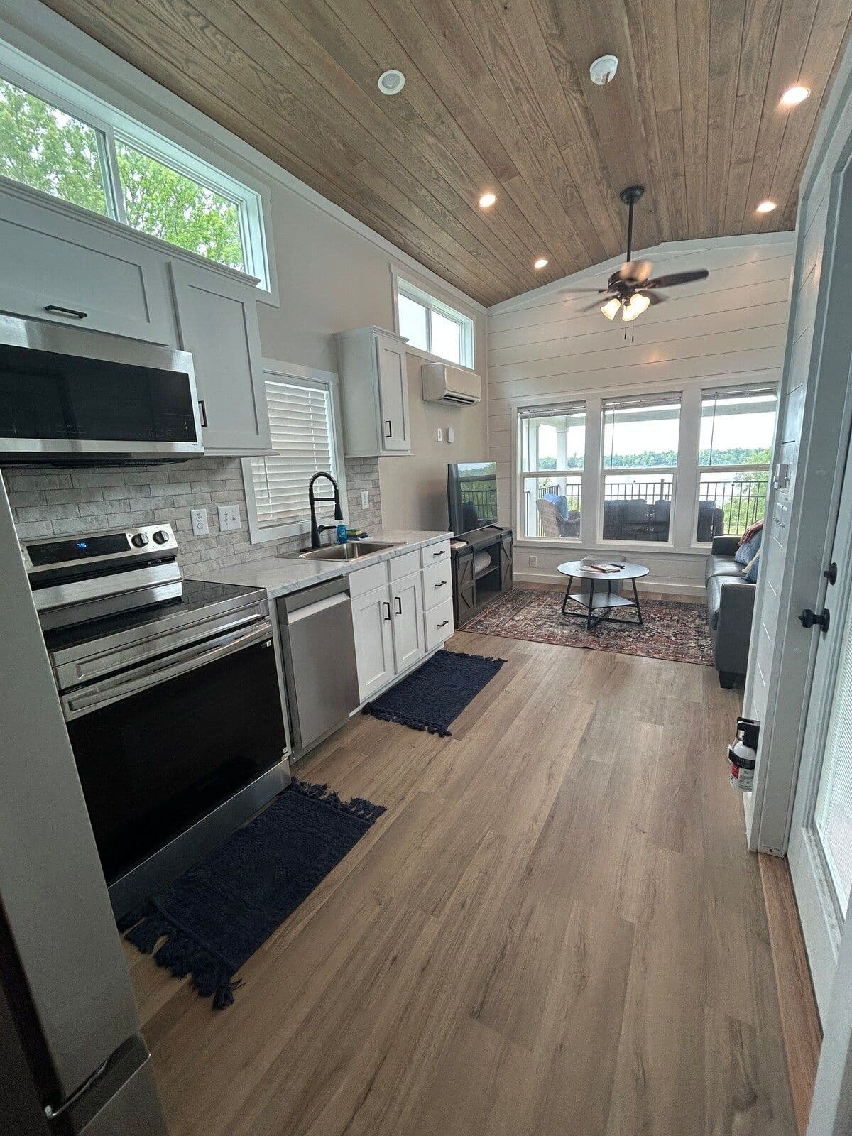 Kitchen with black stainless range, vent hood, white cabinets and navy runners