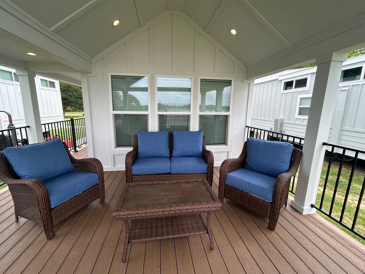 Covered porch with blue wicker chairs and coffee table