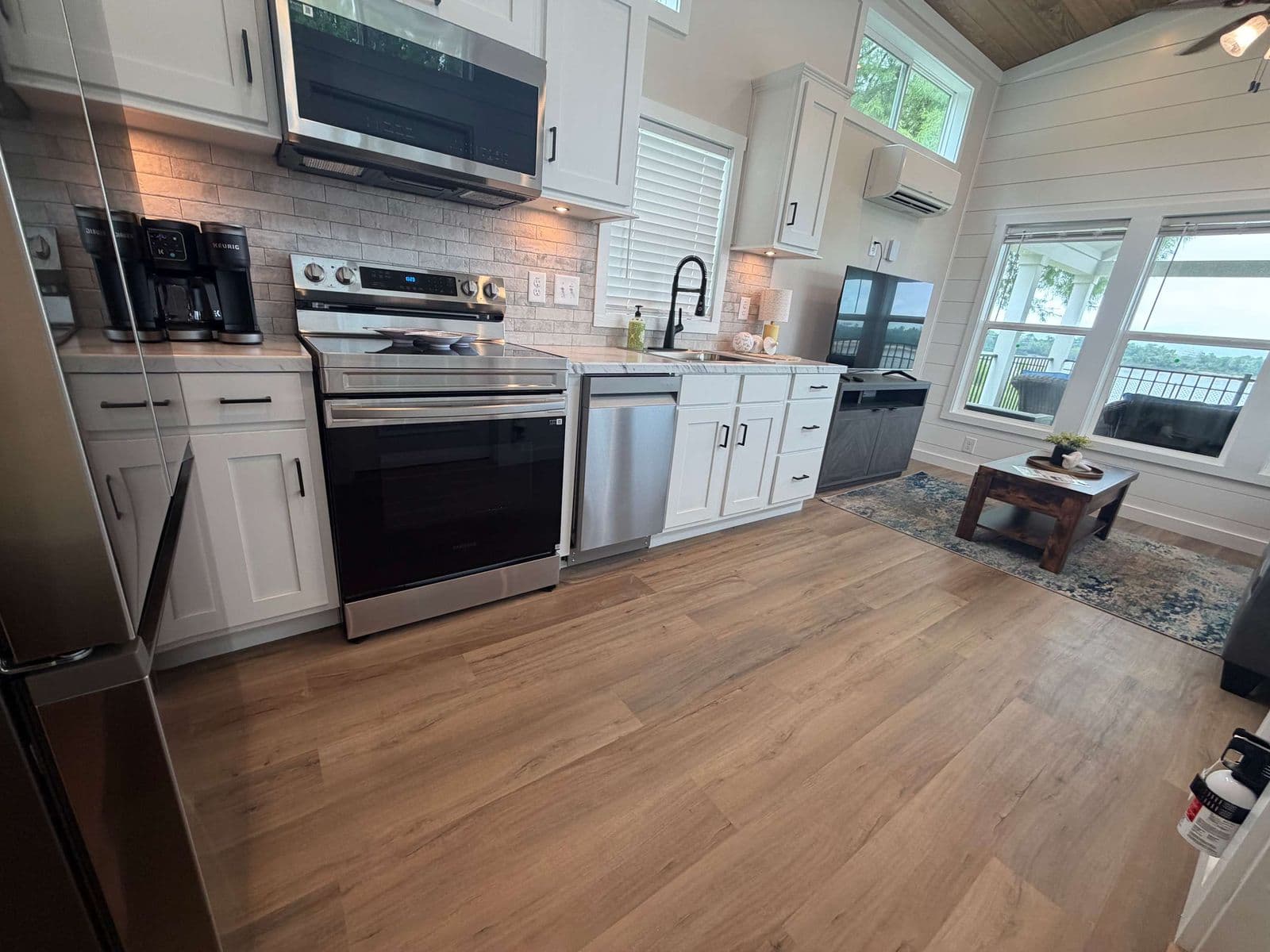 Kitchen with stainless range and microwave hood, white cabinets, marble counter