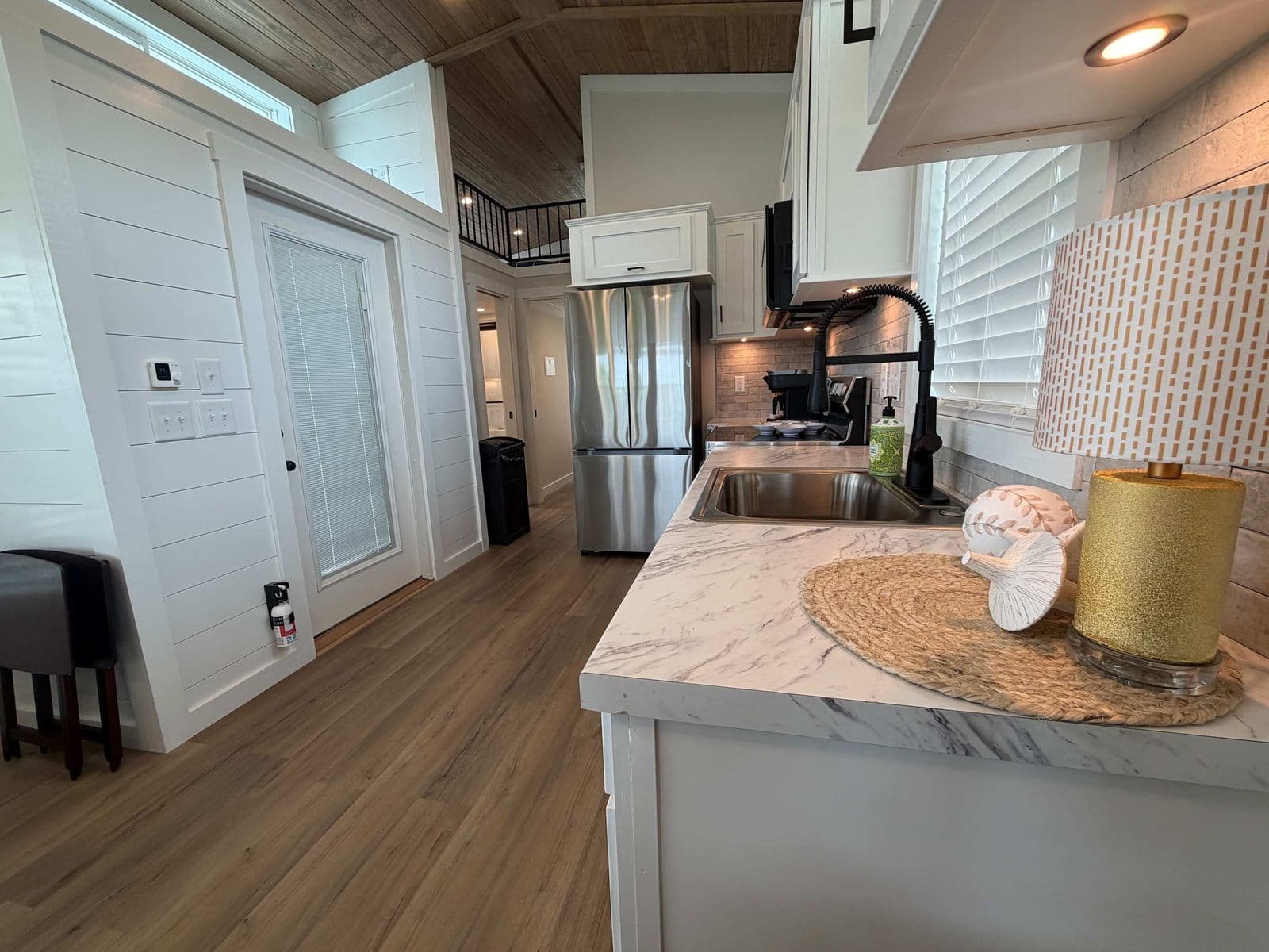 Kitchen counter with marble top, black faucet and fridge