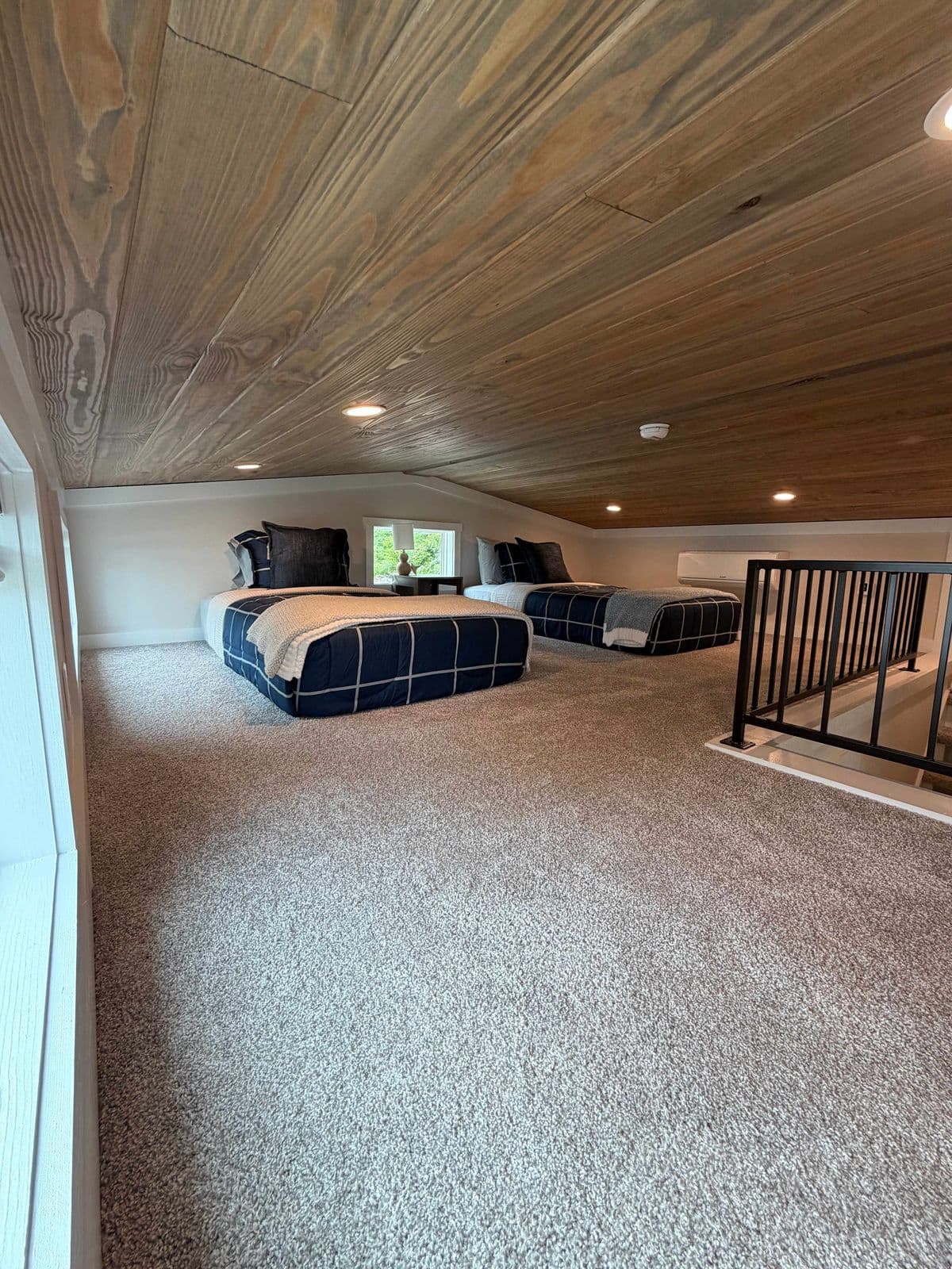 Loft from the stair end with a bed and open carpeted floor