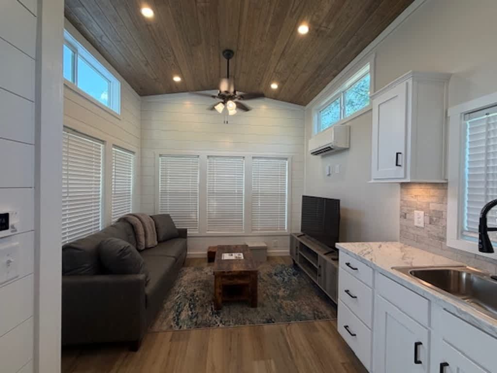 Living area from the kitchen side with sofa and TV