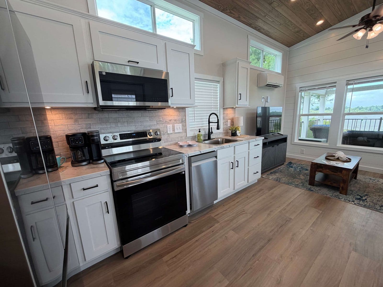 Kitchen with stainless range, microwave hood, gray cabinets and windows