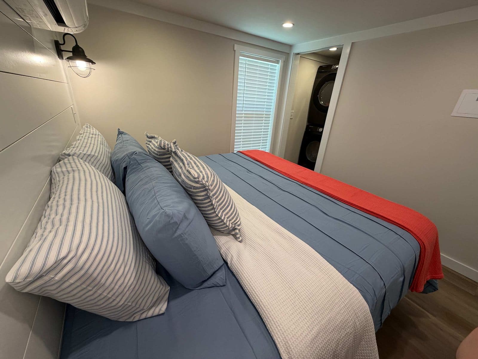 Bedroom with blue and red bedding and striped pillows