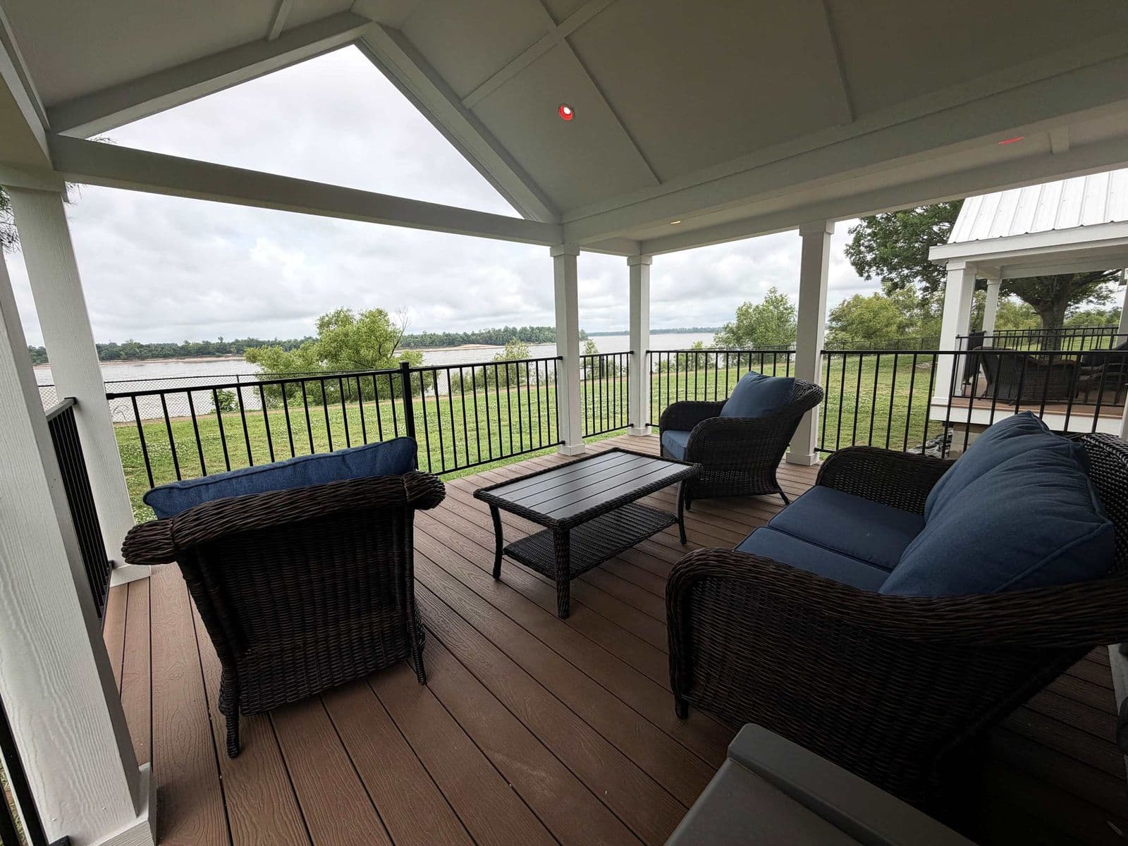 Covered porch with dark cushioned seating and river view