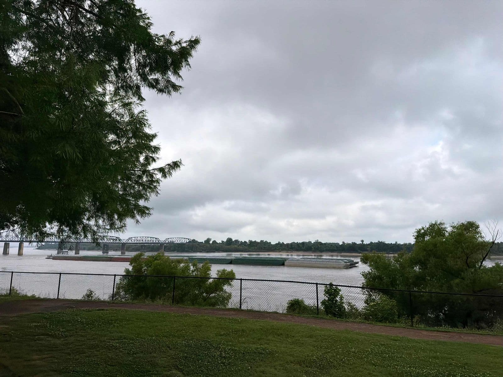 Lawn and river under a cloudy sky