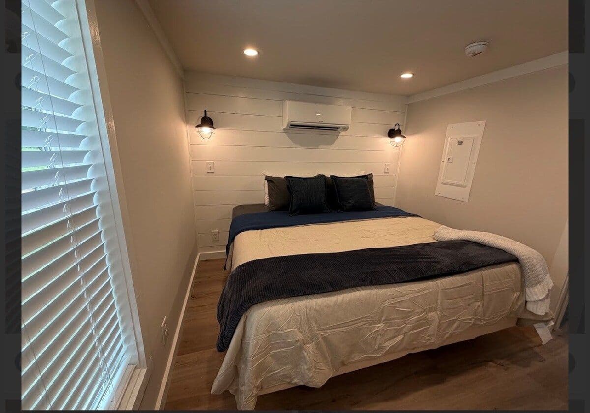 Bedroom, navy and tan bedding, recessed lights and sconces