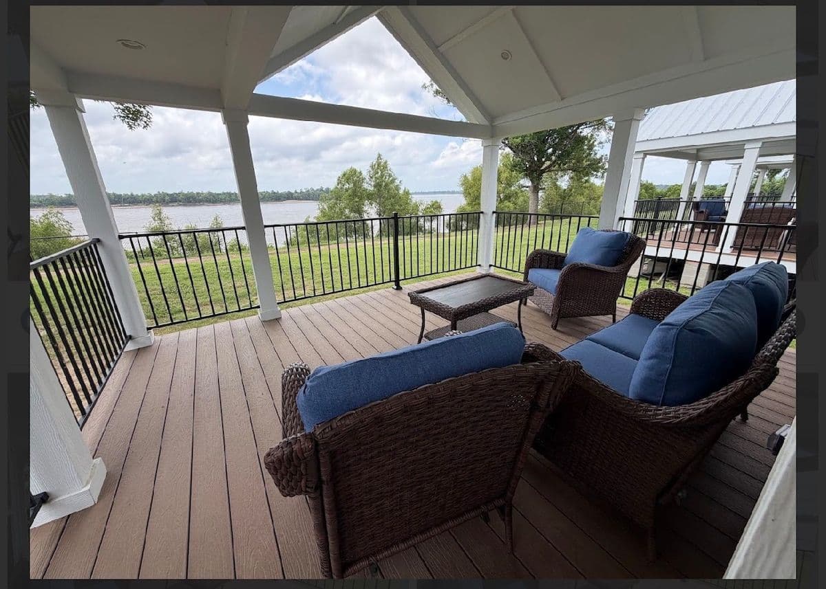 Covered porch with blue cushioned chairs and river view